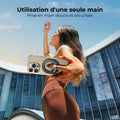 Femme tenant un smartphone avec support anneau, utilisation d'une seule main en extérieur